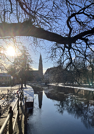 Sol domkyrkotornen och Fyrisån fotade från Haglunds bro