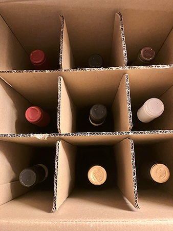 Nio flaskor vin i låda