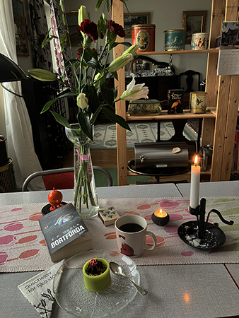 Lördagsfika vid köksbordet med tända ljus noisette från Triller Hopptimisten och boken Bortförda