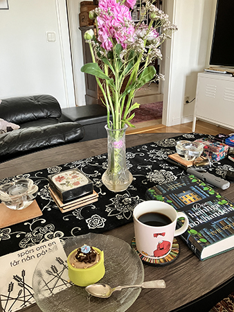 Lördagsfika i vardagsrummet med Noisette Den hemliga bokhandeln och rosa blommor