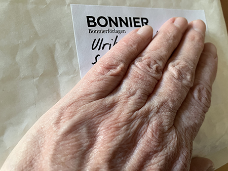 Min hand på paket från Bonniers