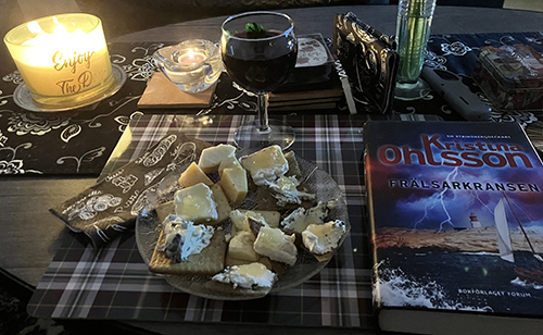 Ostassiett och ett glas rött tända ljus boken Frälsarkransen Ostassiett och ett glas rött tända ljus boken Frälsarkransen