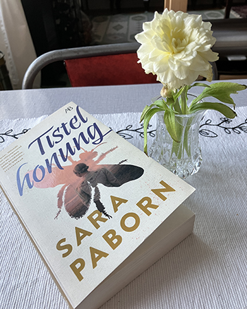 Boken Tistelhonung och gul blomma