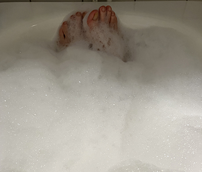Fötter sticker upp ur skumbad