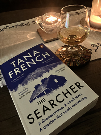 Ett glas calvados tända ljus o boken The Searcher