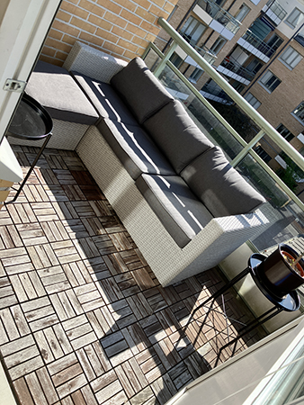 Soffan med kuddar o bord är på plats på balkongen