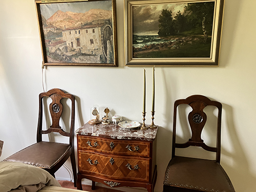 Sovrummet en byrå två ekstolar Den franska kvarnen och ett höstmotiv på väggen