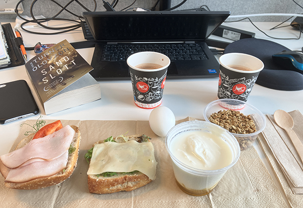 Jobblunch vid skrivbordet med boken Sandslott Jobblunch vid skrivbordet med boken Sandslott