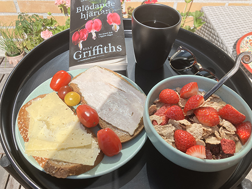 Balkongfrukost med mackor tomater o fil med jordgubbar Blödande hjärtan