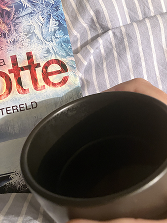 Svart kaffe på sängen i mörkbrun före detta senapsmugg