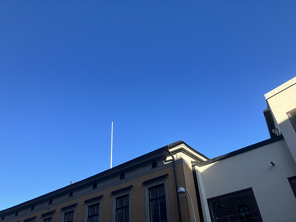 Blå himmel augustimorgon över hus på Drottninggatan