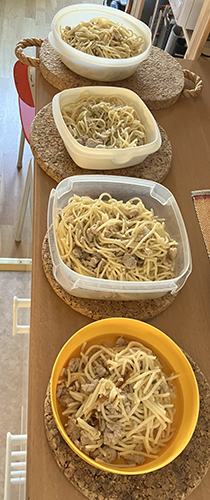 Fyra matlådor med spaghetti och kycklingfärs