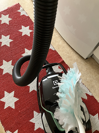 Dammsugare och dammvippa på köksmattan