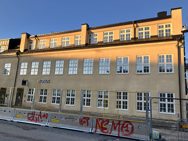 Fonus i Cykelfabrikens hus på Väderkvarnsgatan klotter på vägarbetsstaket