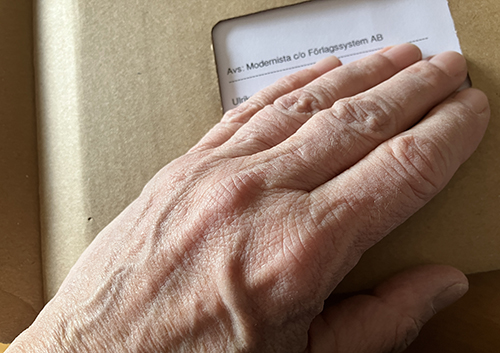 Min hand på brunt paket från Modernista