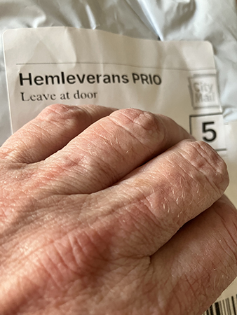 Vitt paket hemleverans prio med min hand på