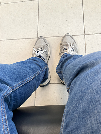 Mina jeansben och fötter i gympadojor