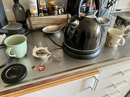 Muggar vattenkokare och tepåse på diskbänken