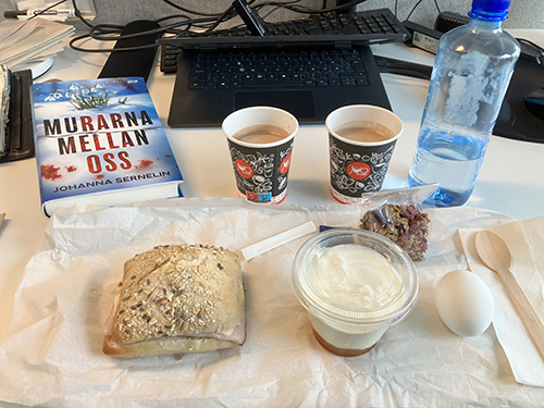 Skrivbordslunch på jobbet med boken Murarna mellan oss