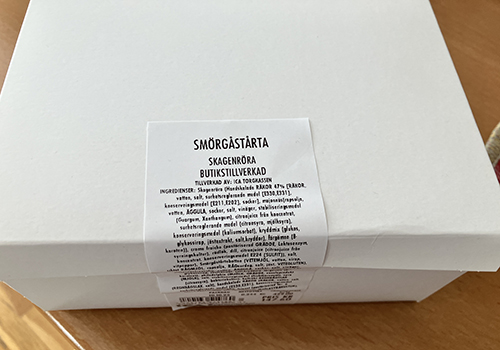 En låda med en bit smörgåstårta från Korgtassen