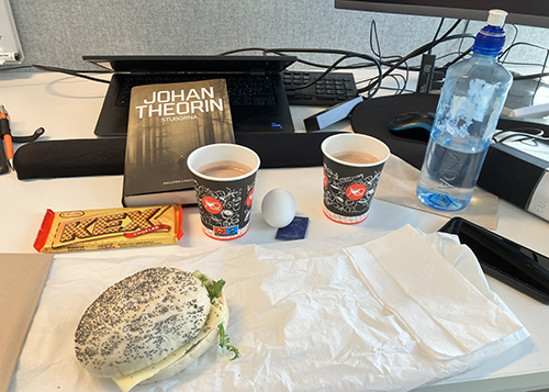 Skrivbordslunch med macka ägg varm choklad kexchoklad och Stugorna
