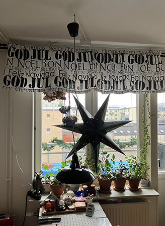 Julgardinkappan o svart adventsstjärna i köksfönstret