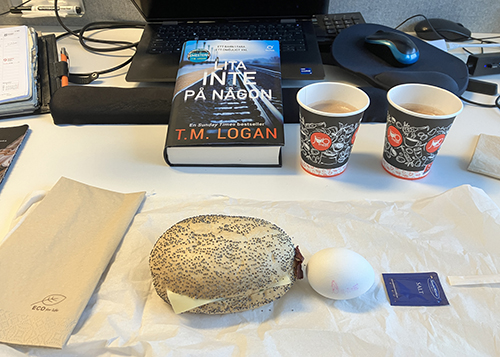 Skrivbordslunch med varm choklad boken Lita inte på någon macka o ägg