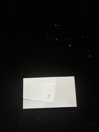 Vid skrivbordet jobbdatorn på mörkt fönster