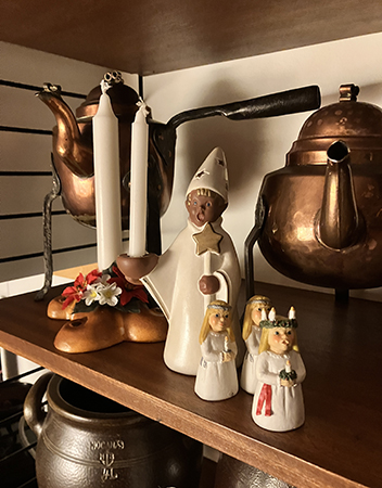 Luciatåg bland kopparsakerna i stringhyllan i köket