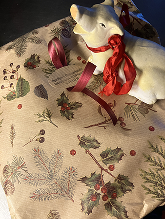 Köksgrisen i rött sidenband ovanpå blompaket