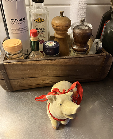 Köksgrisen med rött sidenband om halsen