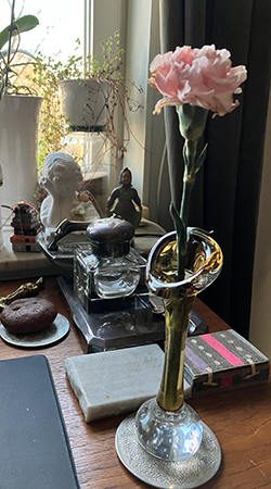 Rosa blomma kvar från buketten från jobbet i vas på skrivbordet