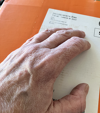 Min hand på orange paket från Bokus