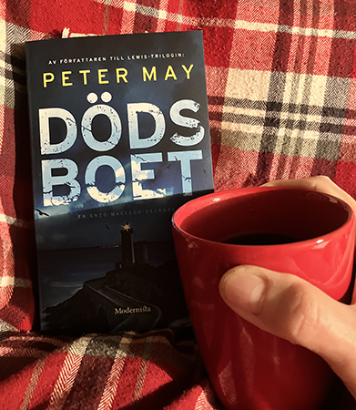 Dödsboet och röd mugg med kaffe på sängen