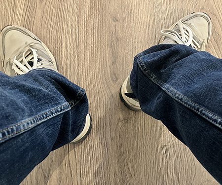 Jeansben och gråa skor i väntrummet