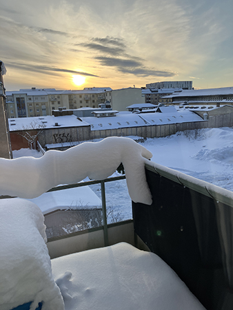 Soluppgång bakom snöig balkong Soluppgång bakom snöig balkong