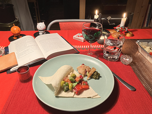 Fyllt bröd med rester från Byblosmiddag uppslagen bok Hopptisarna ett glas rött