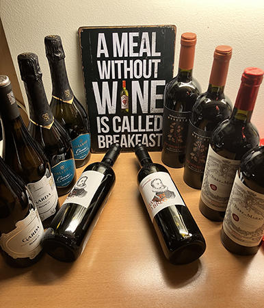 Tio flaskor vin med skylten A meal without wine is called breakfast