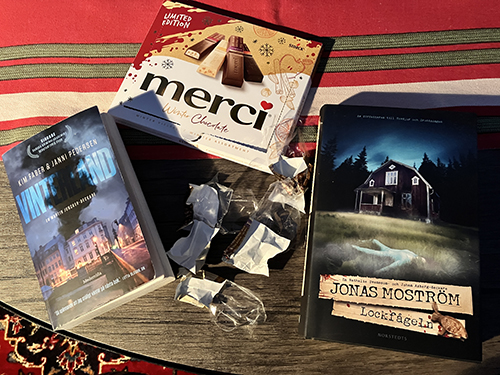 Böckerna Vinterland och Lockfågel med en ask Merci mellan Böckerna Vinterland och Lockfågel med en ask Merci mellan