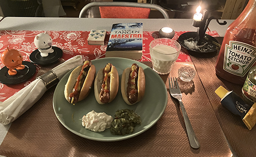 Tre grillade kycklingkorvar med bröd Hopptisarna Maestro levande ljus