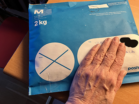 Min hand på blått paket
