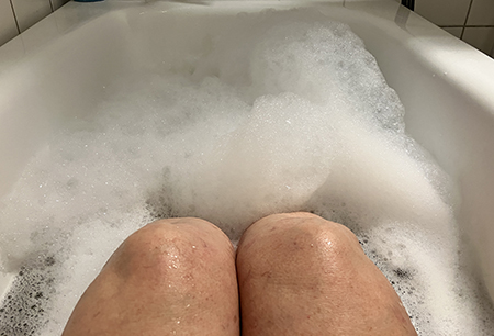 Mina knän sticker upp ur skumbad