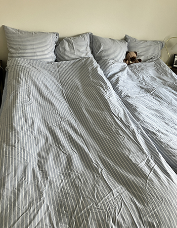 Renbäddat i vitt och ljusblått randigt Nallisen nerbäddad