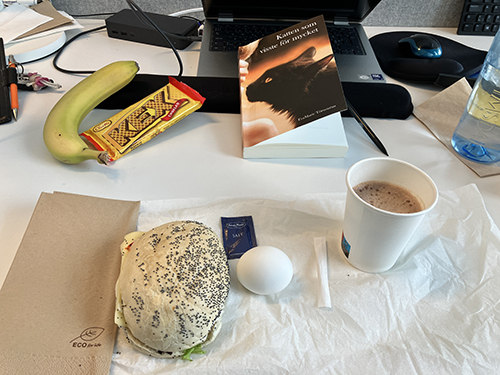 Skrivbordslunch med kattboken macka ägg banan o kexchoklad varm choklad