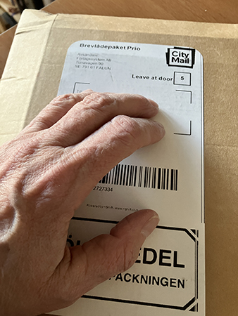 Brunt paket med min hand på