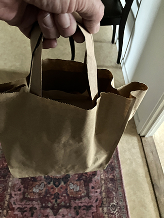 En papperspåse i handen