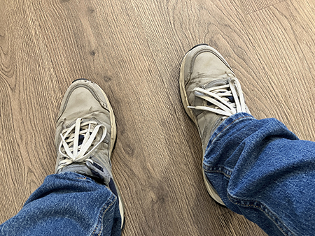 Fötterna och jeansbenen i väntrummet