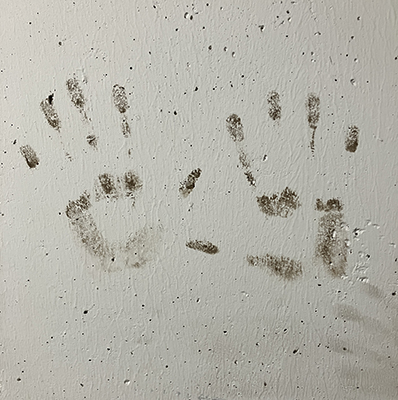 Handavtryck mörka på vit stolpe