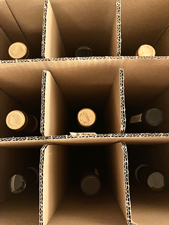 Nio flaskor vin i en låda