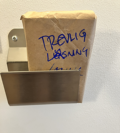 Paket i tidningshållaren med texten Trevlig läsning